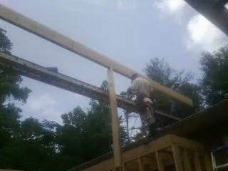 Carpenter setting a ridge beam over a new addition frame — Ice Dam Removal by Roofing Brothers in Worthington Springs