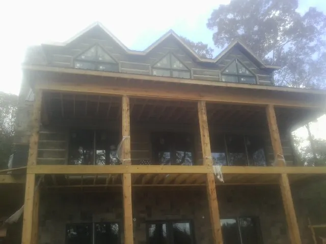 Dormers and porch framing on a large log home under construction — Roof Coating work by our crew in Worthington Springs