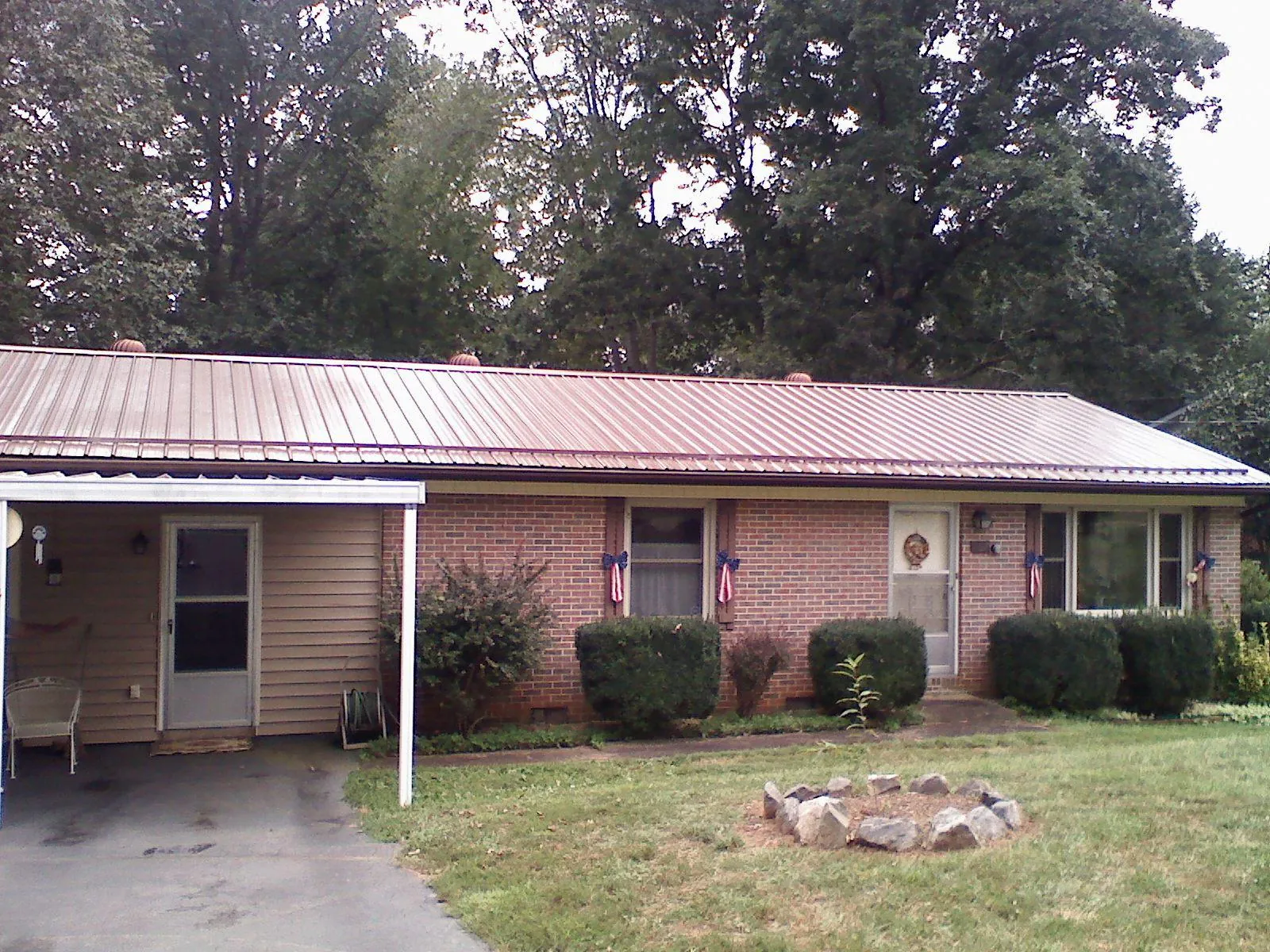Bronze metal roof and carport on a brick ranch home — Roof Repair work by our crew in Worthington Springs